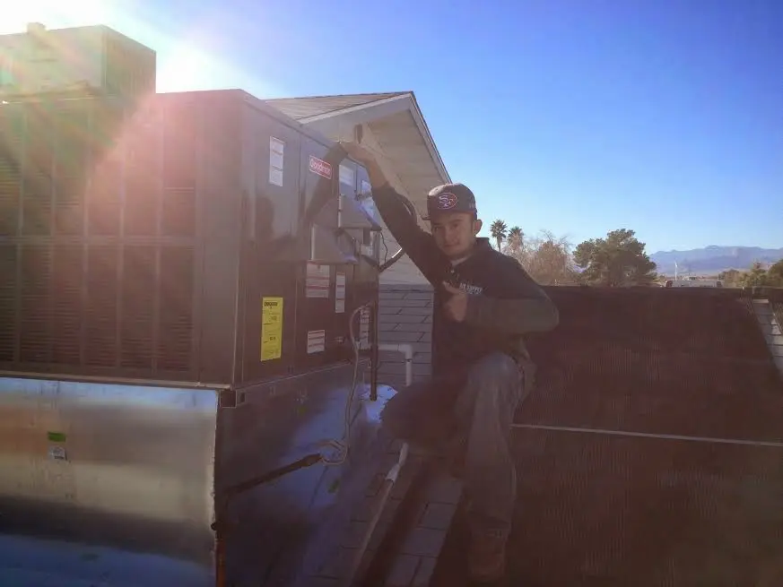 HVAC technician performing AC Tune-Up on a rooftop unit in Harrisburg